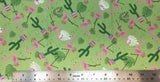 Flat swatch cartoon flamingos and cactus printed fabric in green (faded green fabric with tossed cartoon pink flamingos, white and green leaves, green cactus in pink planter)