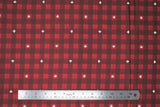 Flat swatch Canada themed printed fabric in red (red/black plaid with white maple leaf accents)