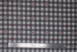Flat swatch Canada themed printed fabric in grey (white/grey plaid with red maple leaf accents)