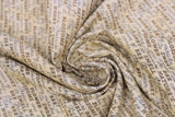 Swirled swatch assorted bee printed fabric in honey yellow cursive (pale yellow fabric with black and gold text allover related to bees/honey in various fonts)