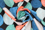 Swirled swatch black wool fabric (black fabric with horizontal stripes of circular balls of yarn in orange, blue, teal, navy, light grey, light teal, alternating)