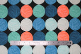 Flat swatch black wool fabric (black fabric with horizontal stripes of circular balls of yarn in orange, blue, teal, navy, light grey, light teal, alternating)