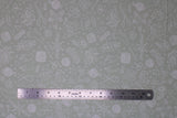 Flat swatch knitting fabric (grey fabric with small tossed knitting related emblems allover in white: needles, crochet hooks, yarn, hands, socks, scissors, etc.)