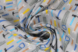 Swirled swatch work zone themed fabric in tools (light grey fabric with assorted tools hammers, wrenches, saws in black/white/grey with blue/yellow/orange handles)