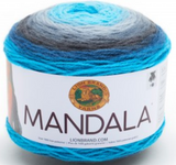A cake of Lion Brand Mandala yarn in colourway spirit (bright blues light to dark and grey)
