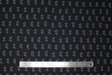 Flat swatch Whiskers fabric (black fabric with repeated white cat top of head and whiskers outline allover)