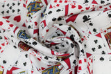 Swirled swatch man cave themed fabric in cards red (deck of cards face up tossed collage on red background)