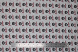 Flat swatch Bob Ross collection fabric in Bob Ross print (light grey fabric with tiled black and white Bob Ross heads with red signatures beneath)