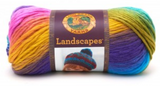 A ball of Lion Brand Landscapes yarn on white background in colourway boardwalk (yellow, orange, pink, purple, blue, green)