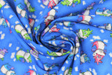 Swirled swatch magical themed printed fabric in print dragons (medium blue fabric with tiny white cloud puffs and cartoon dragons in green/pink/blue/purple colours)