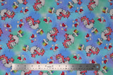 Flat swatch magical themed printed fabric in print unicorns (sky blue and light green marbled fabric with white cartoon unicorns with pink manes/tails standing on mini cloud platforms with 1/4 rainbows, tossed white and pink hearts)