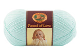 A ball of Lion Brand Pound of Love yarn on white background in shade pastel green (pale green/blue)