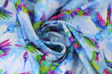 Swirled swatch Light Blue fabric (light blue fabric with multicoloured hummingbirds and silhouettes allover)