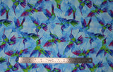 Flat swatch Light Blue fabric (light blue fabric with multicoloured hummingbirds and silhouettes allover)
