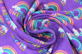Swirled swatch I believe purple fabric (purple fabric with repeated rainbow arches with white clouds on either end and "I believe in" text in blue "unicorns" text in rainbow colours)