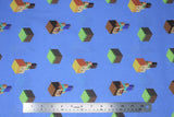 Flat swatch Minecraft (licensed) printed fabric in Alex and Steve toss (2 characters and grass squares on blue)