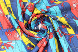 Swirled swatch Marvel (licensed) fabric in Spiderman Swing (cartoon swinging spidermans on blue/red/yellow abstract tile with spiders and webs)