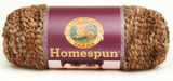 A ball of Lion Brand Homespun in a boucle texture and colourway Barley (tan, mid brown, dark brown, reddish brown)