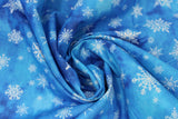 Swirled swatch of snowflake printed fabric in blue (blue marbled look fabric with white tossed snowflakes in various sizes and styles)
