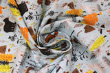 Swirled swatch Canadian Boreal fabric (pale blue fabric with busy tossed cartoon style Canadian related fall themed emblems allover: trees, leaves, bears, moose, beavers, wolves, owls, sprigs, acorns, etc.)
