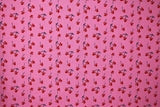 Flat swatch MM Cherry Sweet fabric (bubblegum pink fabric with tossed black stem cherries with red mickey mouse shaped fruit tossed allover)