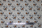 Flat swatch Pumpkin Mickey fabric (white fabric with tossed halloween related cartoon emblems and mickey mouse characters)
