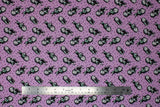 Flat swatch Sally Dot fabric (mauve fabric with dots allover and tossed sally character in black and grey allover)