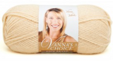 A ball of Lion Brand Vanna's Choice yarn on white background in shade beige
