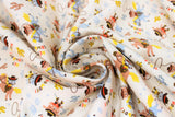 Swirled swatch Howdy fabric (off white fabric with tossed cartoon cat and dog cowboys on blue horses and hobby horses with tossed cacti in yellow, blue and brown shades and lassos, "Hey Cowboy!" text)