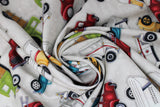 Swirled swatch tossed trucks fabric (off white fabric with large full colour tossed assorted trucks in: red, green, blue, yellow)