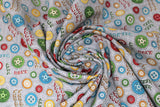 Swirled swatch vroom vroom fabric (grey fabric with tossed colourful wheels in various sizes/styles: red, green, blue, yellow, orange. "Vroom vroom" text, "honk honk" text, etc.)
