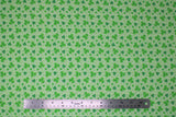 Flat swatch St. Patrick's Day themed fabric in assorted green shamrocks on green