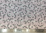 Flat swatch narwhal printed fabric in pink (pale pink and white pebble/water texture print background with tossed drawn narwhals, starfish, and wave lines in black)