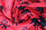 Swirled swatch bearfoot fabric (red fabric with black bear silhouettes and small black tree outlines repeated)