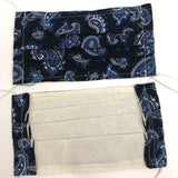 Front and back view of mask with white elastic ear loops (dark blue almost black mask with medium sized paisley design in white, blue, grey and purple)