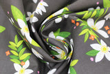 Swirled swatch grove fabric (black fabric with medium sized white pointy floral heads with green leaves and stems tossed allover with tiny red and pink floral heads tossed)