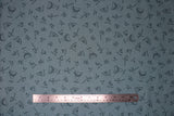 Flat swatch Shark Teeth fabric (dark blue-grey fabric with tossed shark tooth outlines in various styles with small written labels)