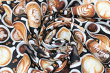 Swirled swatch fresh brew fabric (top view of white mugs in various sizes holding many styles of coffee/lattes with brown coffee beans in between spaces, printed allover)
