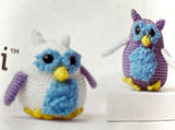 Completed Amigurumi owls (white/purple bodies with opposite colour wings, yellow beak and feet, blue fuzzy tummy and eye accents)