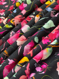 Swirled swatch knit material in botanical black (pink flowers with green and yellow leaves on black with a slight watercolour look)