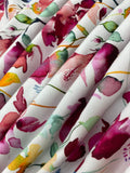 Swirled swatch knit material in botanical white (purple and blue flowers with green and yellow leaves on white with a watercolour look)