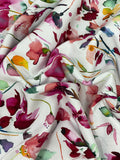 Crinkled swatch knit material in botanical white (purple and blue flowers with green and yellow leaves on white with a watercolour look)