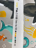 Raw hem swatch knit material in deep sea life grey (doodled sharks, octopi, fish, and jellyfish with nautical emblems on grey)