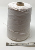 A large spool of white elastic twine with measuring tape in front indicating that the spool is about 4 inches wide