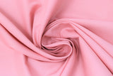 Swirled swatch Broadcloth Solid fabric in shade Cinnamon (bright pink/orange)