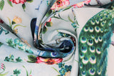 Swirled swatch feather themed print in feathered peacock (light blue fabric with blue/turquoise graceful peacocks on branches with tossed pink/white/blue floral and stems)