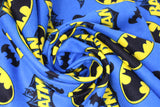 Swirled swatch batman trademark fabric (bright medium blue fabric with tossed yellow and black batman logos, black bat silhouettes, and "Batman" text with character behind, tossed allover)