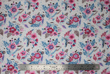 Flat swatch wildflowers fabric (white fabric with light and dark pink floral heads with blue stems tossed allover with subtle blue and black dots here and there, brown leafy stems)