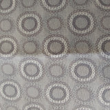 Square swatch upholstery fabric with circles (within circles) print in neutral/grey/beige shades