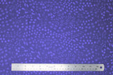 Flat swatch migration themed printed fabric in animal tracks (dark purple fabric with tiny assorted animal tracks allover in lighter purple)